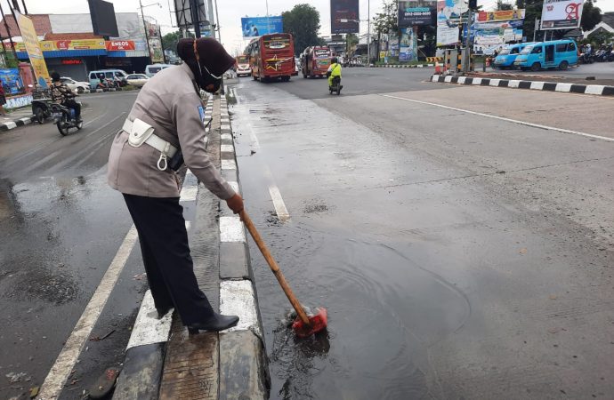 Polisi Polres Cirebon Kota, Bersihkan Genangan Air Antisipasi Arus Mudik Terhindar Kecelakaan